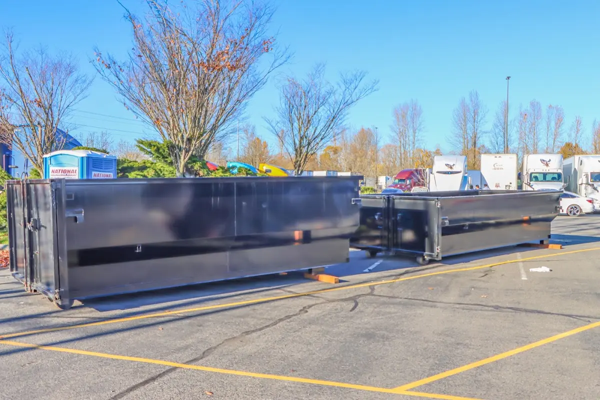 Professional dumpster rental service with roll-off container on residential driveway in East Manchester